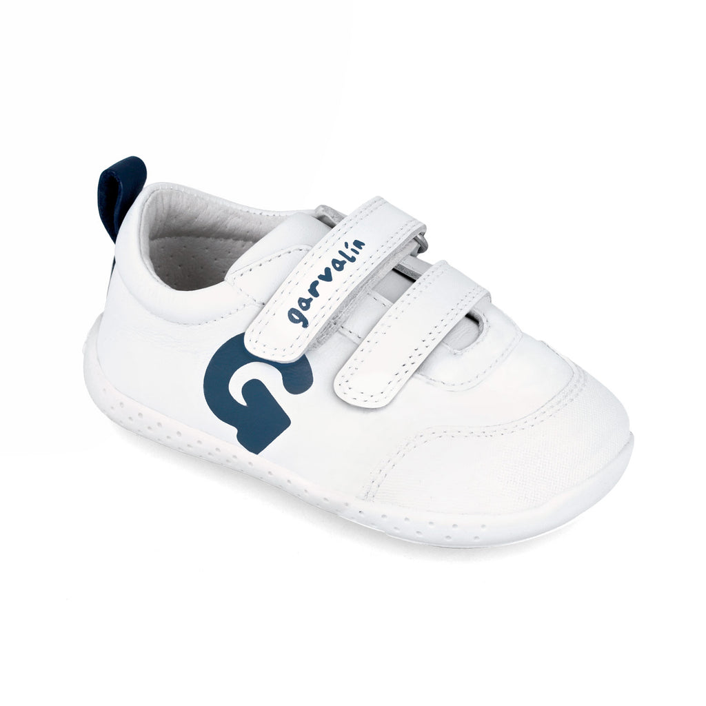 Zapatilla Garvalín respetuosa en blanco y azul marino con cierre de contacto y flexibilidad para el movimiento natural del pie.
