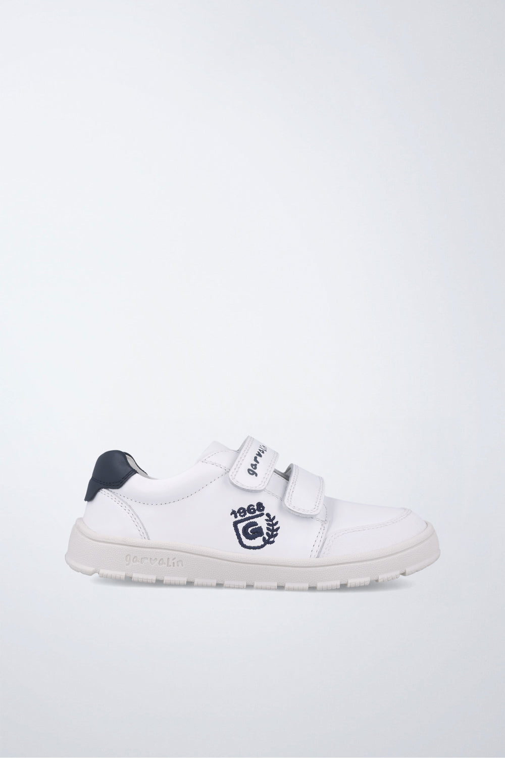 Zapatilla infantil Garvalín barefoot en blanco y azul marino con cierre de contacto y suela flexible.