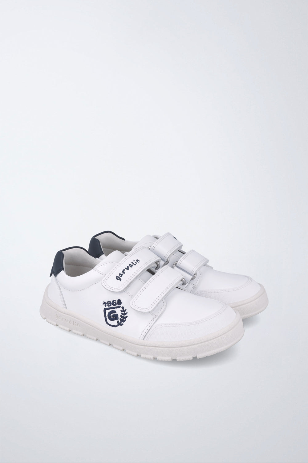 Zapatilla infantil Garvalín barefoot en blanco y azul marino con cierre de contacto y suela flexible.