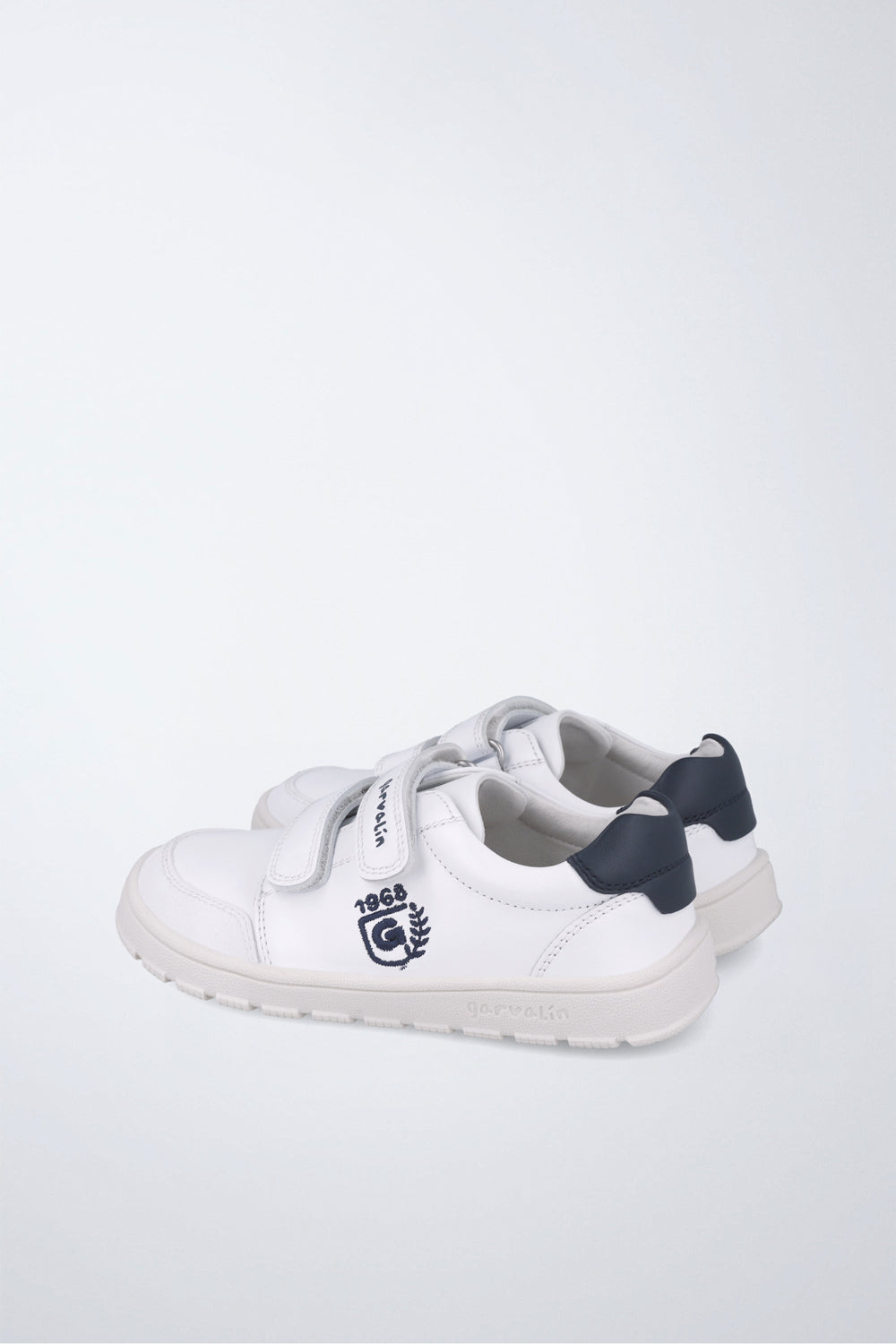 Zapatilla infantil Garvalín barefoot en blanco y azul marino con cierre de contacto y suela flexible.